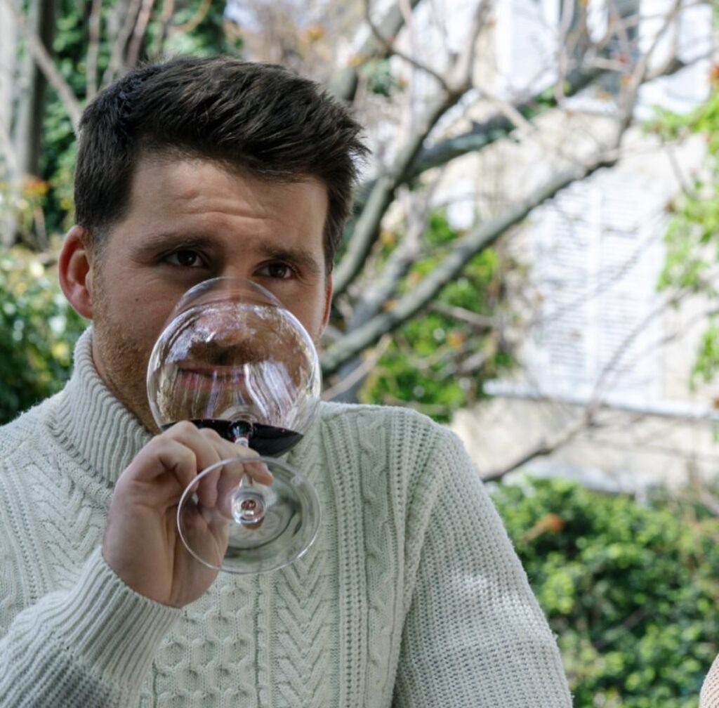 Image de Michel sentant un verre de vin rouge (deuxième étape de la dégustation)